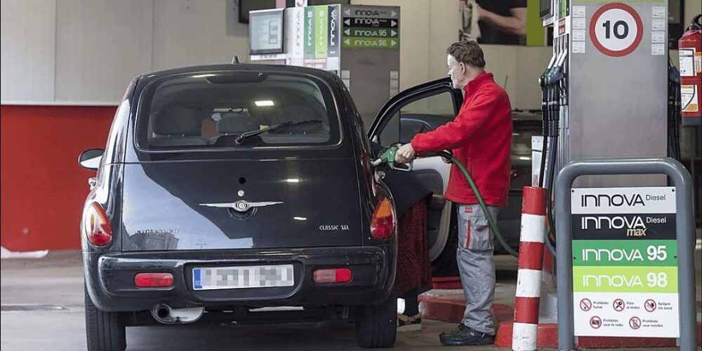 Surtidor de gasolina en una gasolinera de Cantabria con el cartel de rebaja del IVA de los carburantes visible.